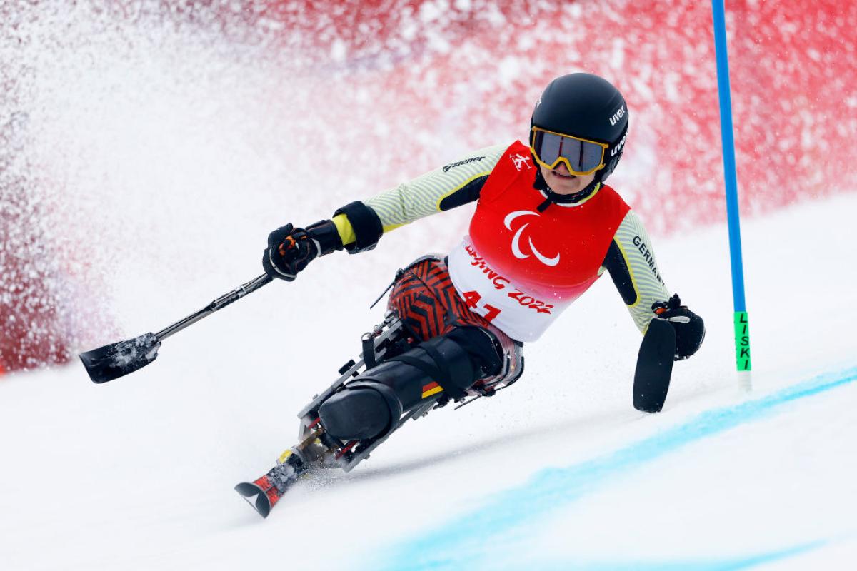 A female sit-skiing athlete is in action