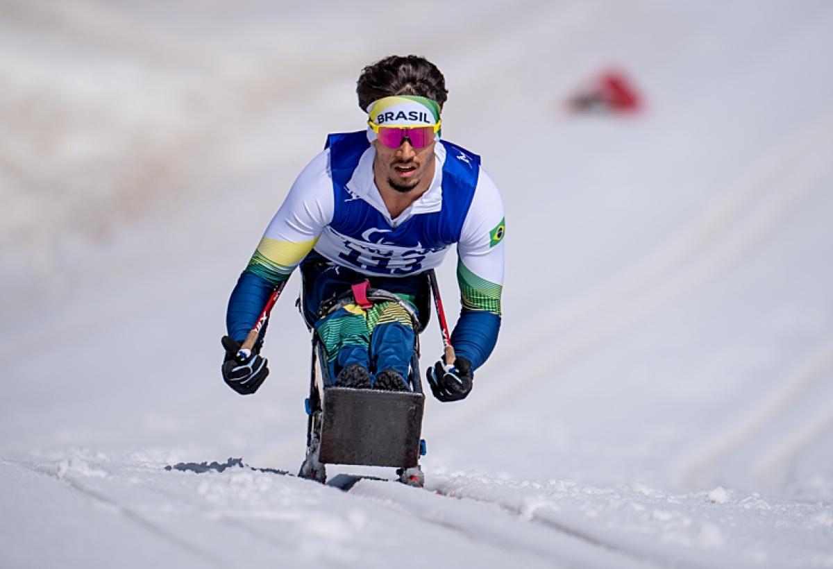 A male Paralympic sit-skier competes in Para cross-country skiing during Beijing 2022