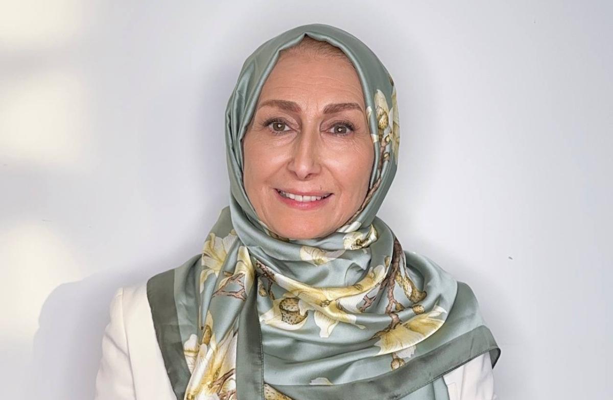 Sima Limouchi smiling in front of a white wall