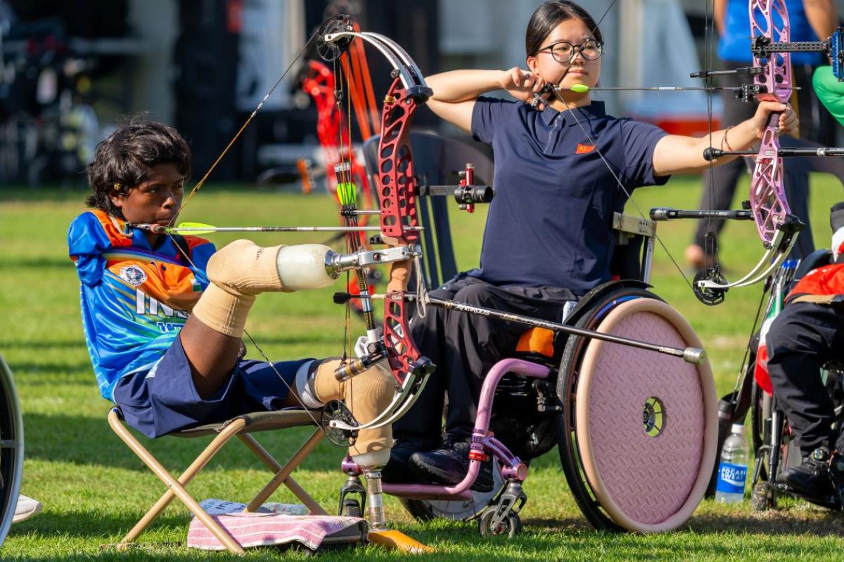 Two female archers - one athlete in a wheelchair and one athlete using her prosthetic legs to shoot - are competing at the Asian Youth Para Games