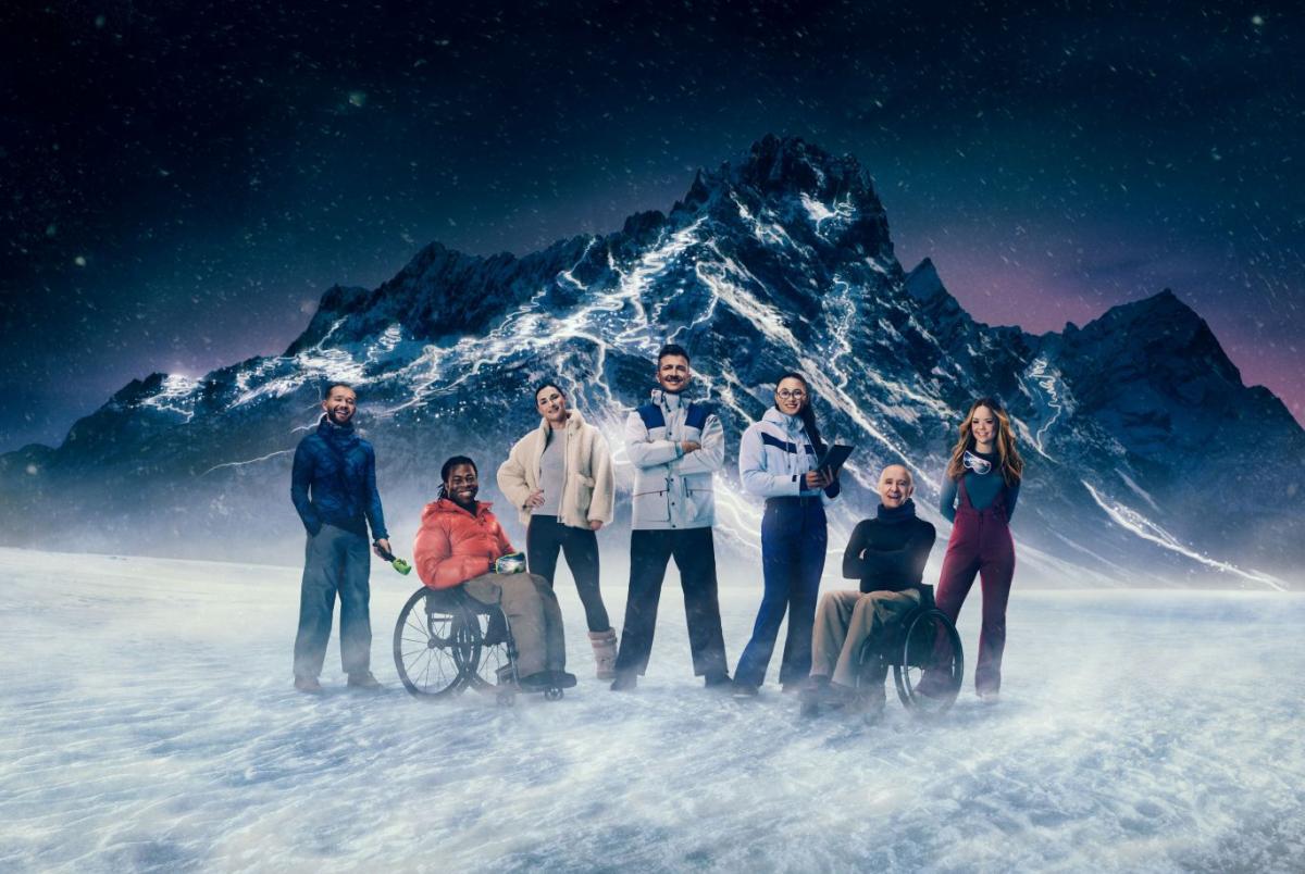 Seven people stand in front of a snowy mountain, which will host the Milano Cortina 2026 Paralympics, 