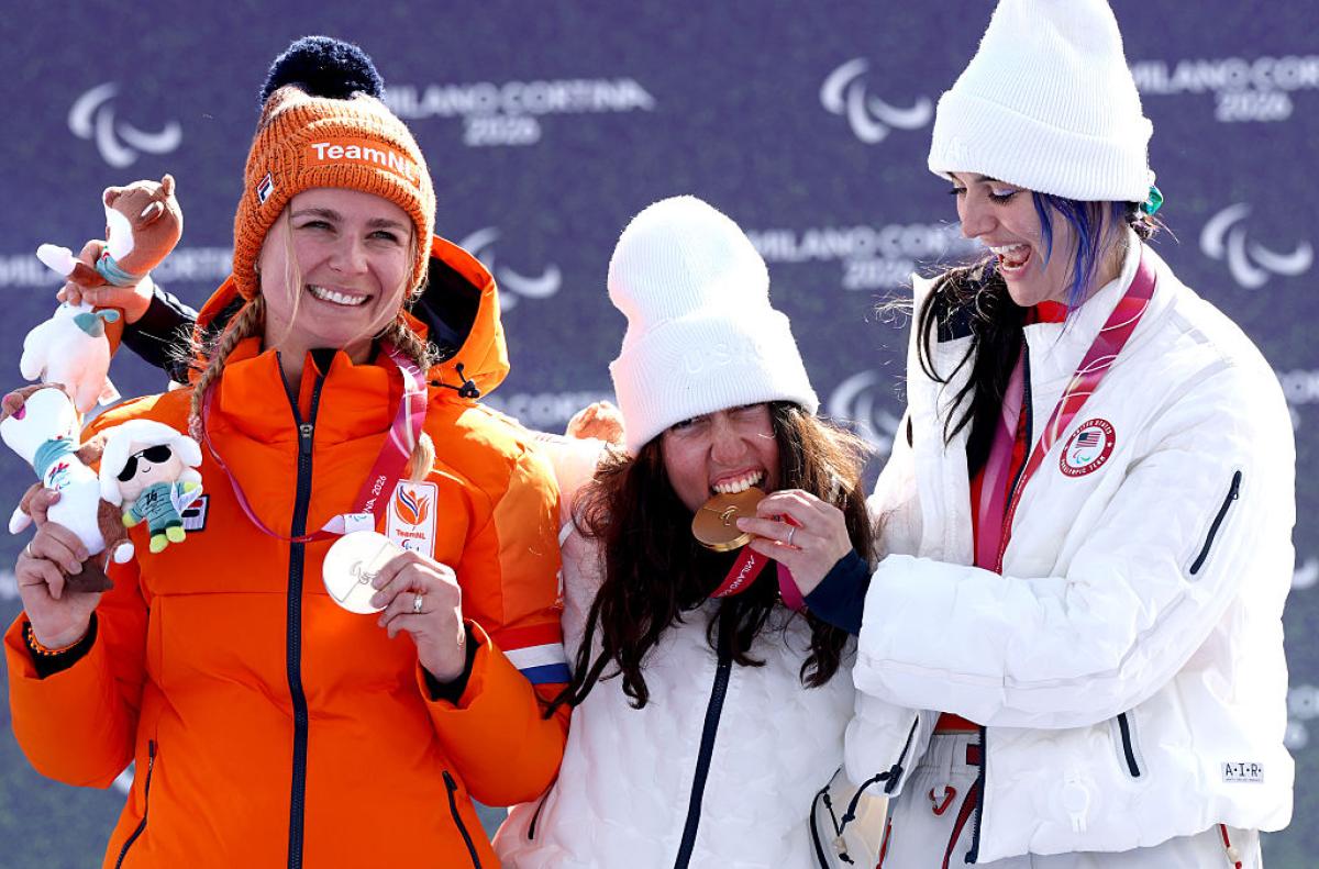 Three female athletes are celebrating on the podium