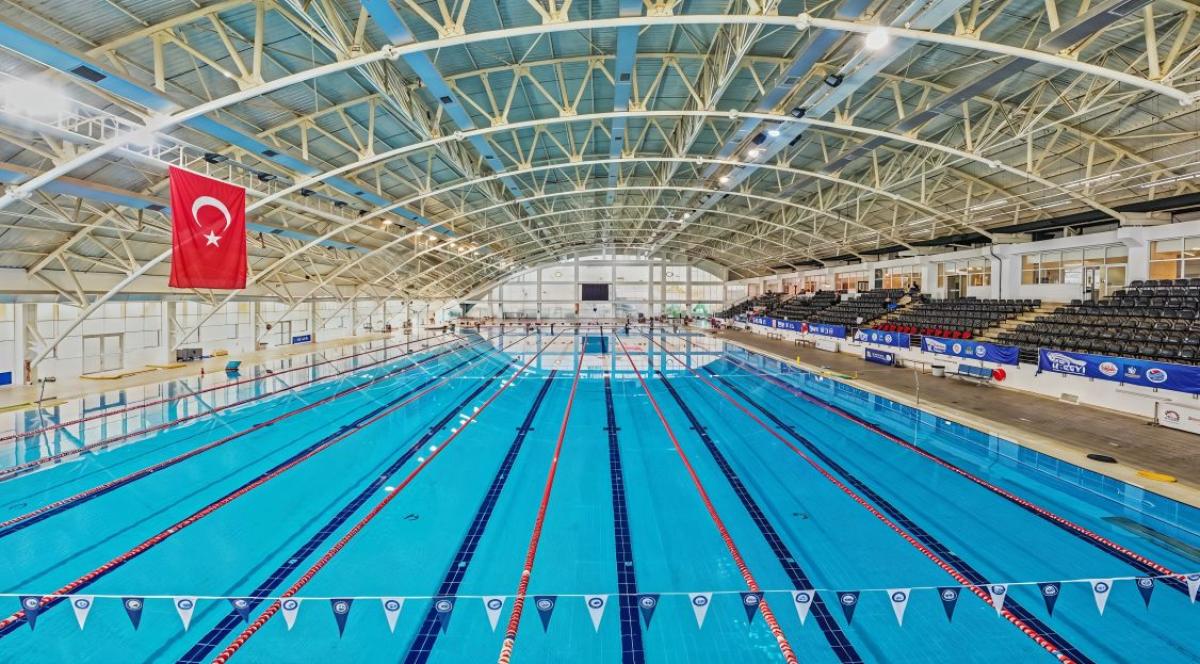 An indoor swimming pool with empty stands