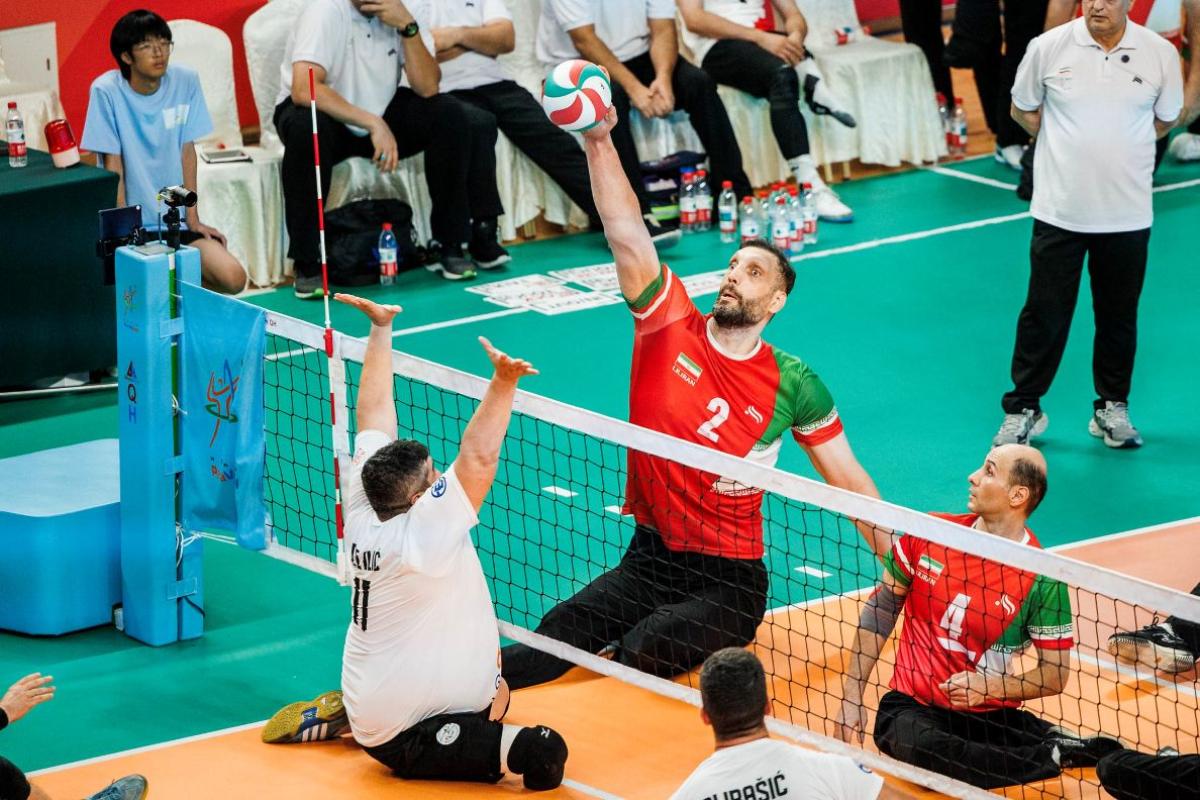 Iranian sitting volleyball athlete returns a shot in front of a net