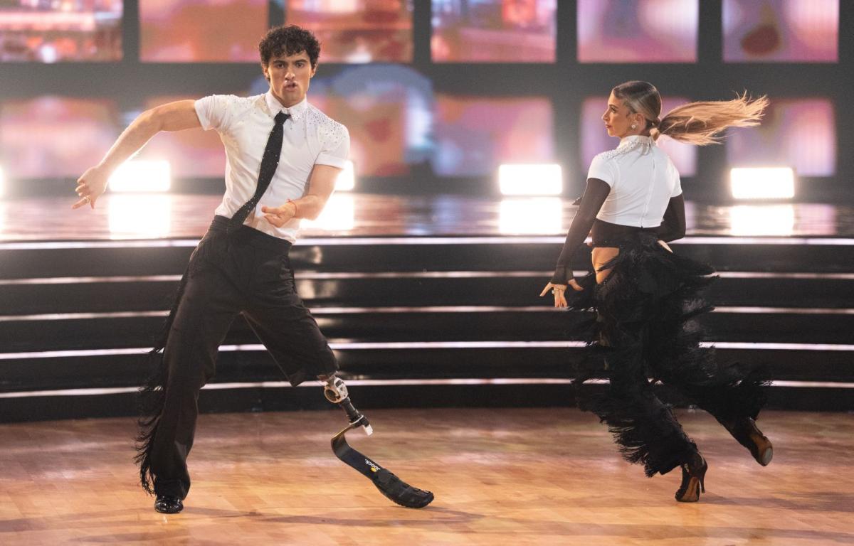 A man with a prosthetic leg dancing next to a female dancing partner