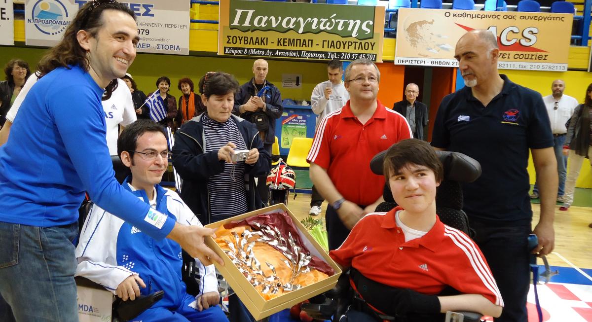 Man handing a Boccia player some flowers