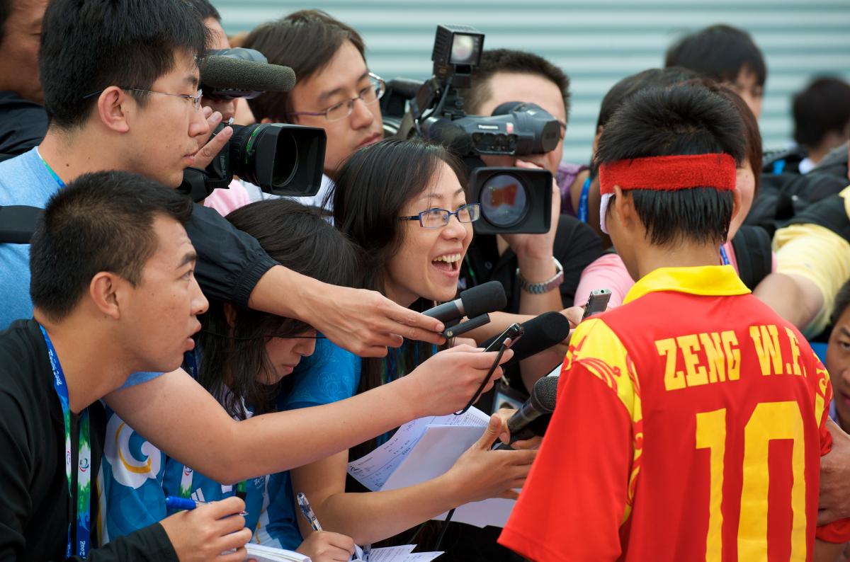 A picture of plenty of journalists trying to interview a 5-a-side football player.