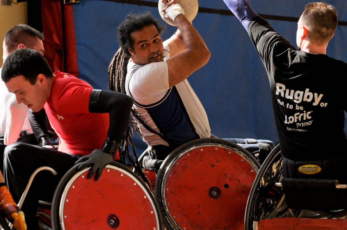 A picture of a man in a wheelchair trying to make a pass with a ball.