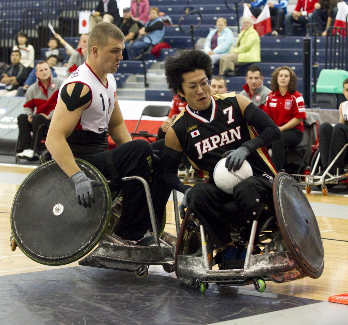 A picture of man in a wheelchair resisting to a choch with another wheelchair.