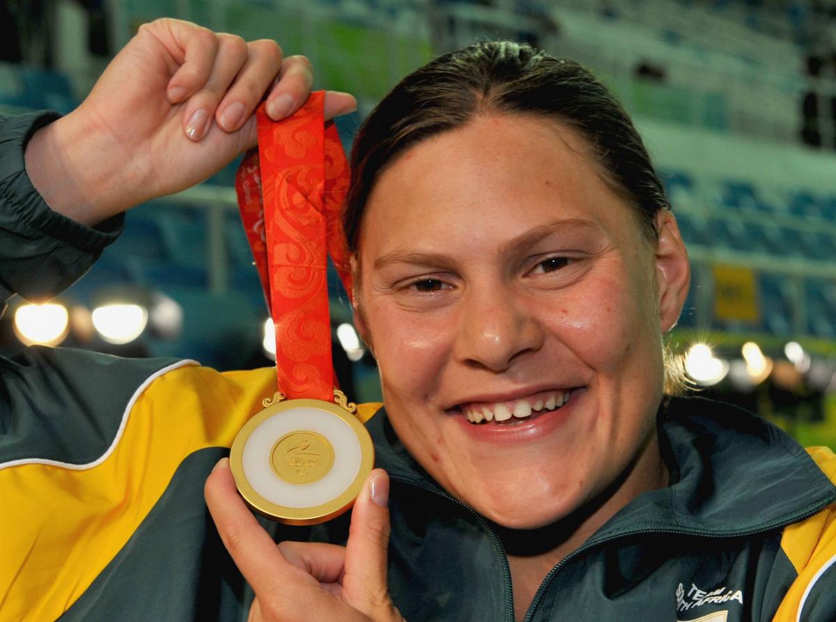 A picture of a girl showing a gold medal after her victory