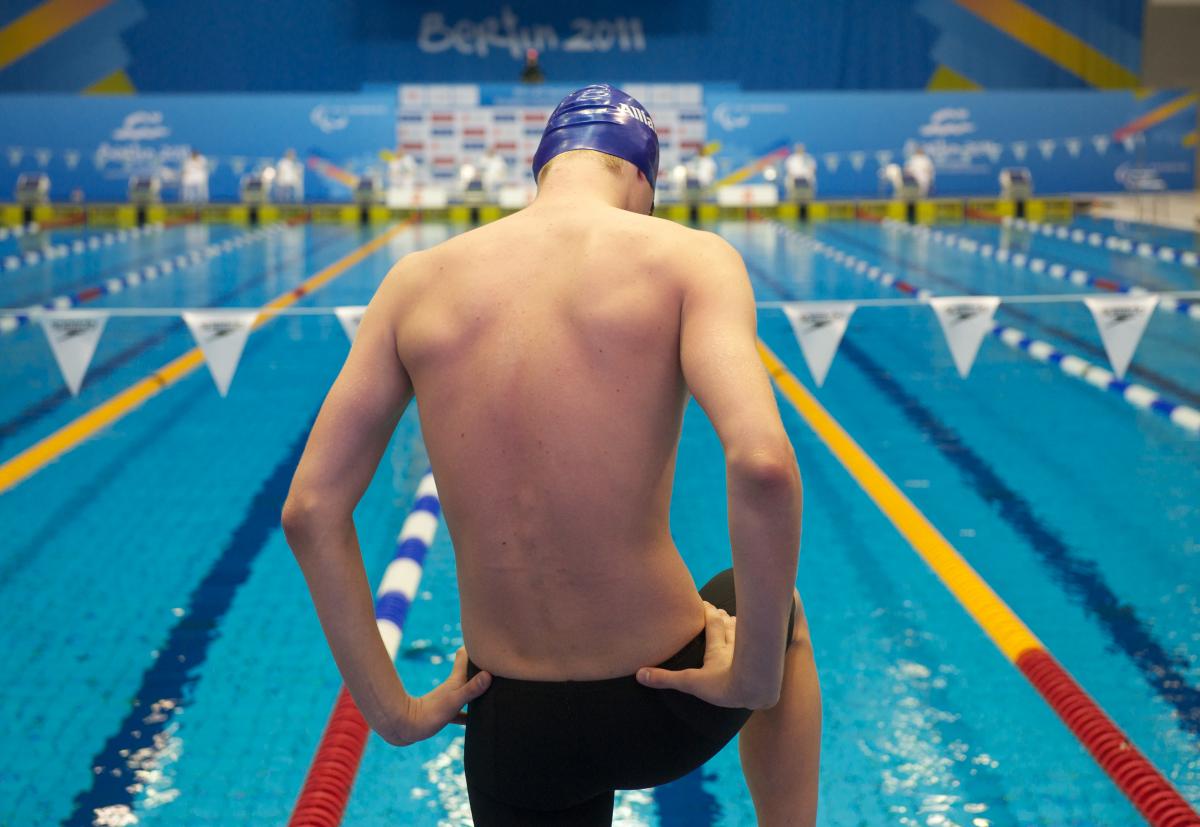 A picture of a man standing in front of a pool