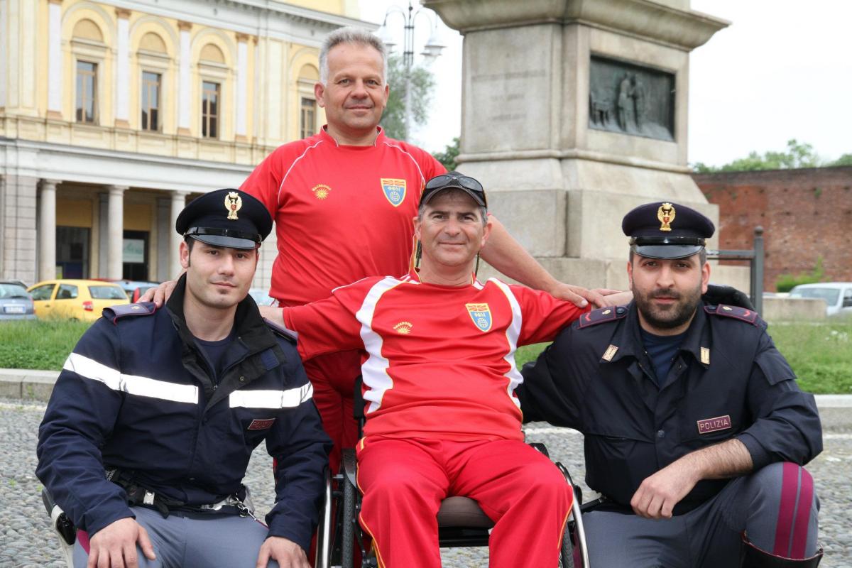 A picture of a man in a wheelchair posing between 2 policemen