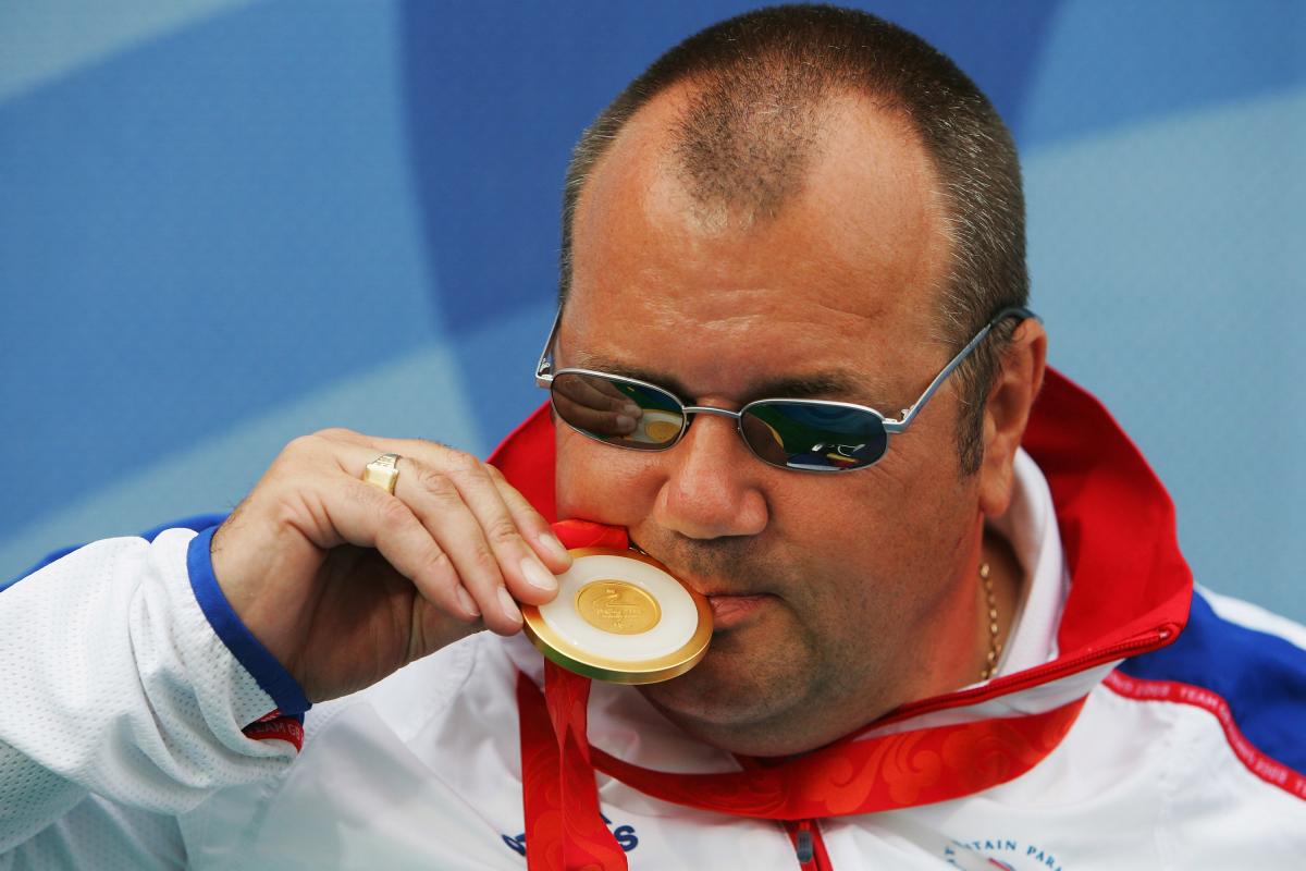 A picture of a man kissing his gold medal
