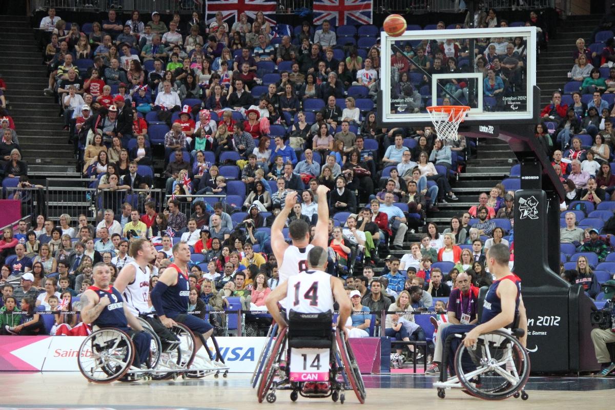 A picture of a man in a wheelchair shooting during a basketball match