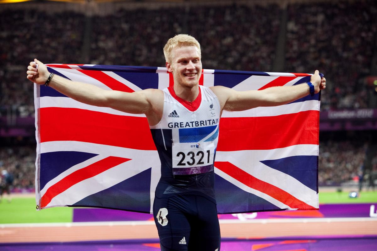 A picture of man celebrating his victory with a British Flag