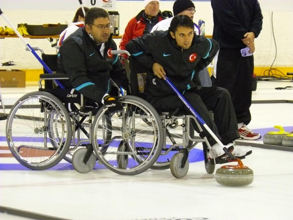 A picture of a man in wheelchair playing curling