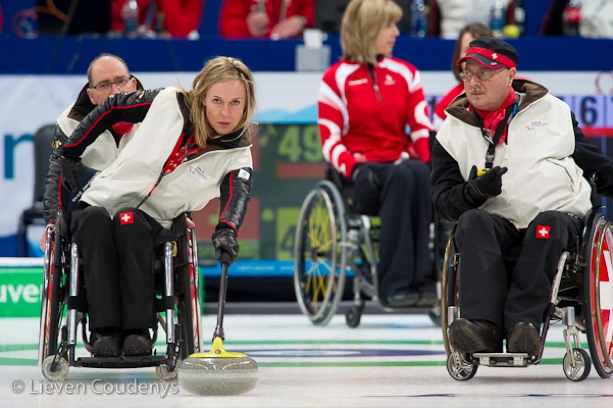 A picture of a man and a woman in a wheelchair playing curling