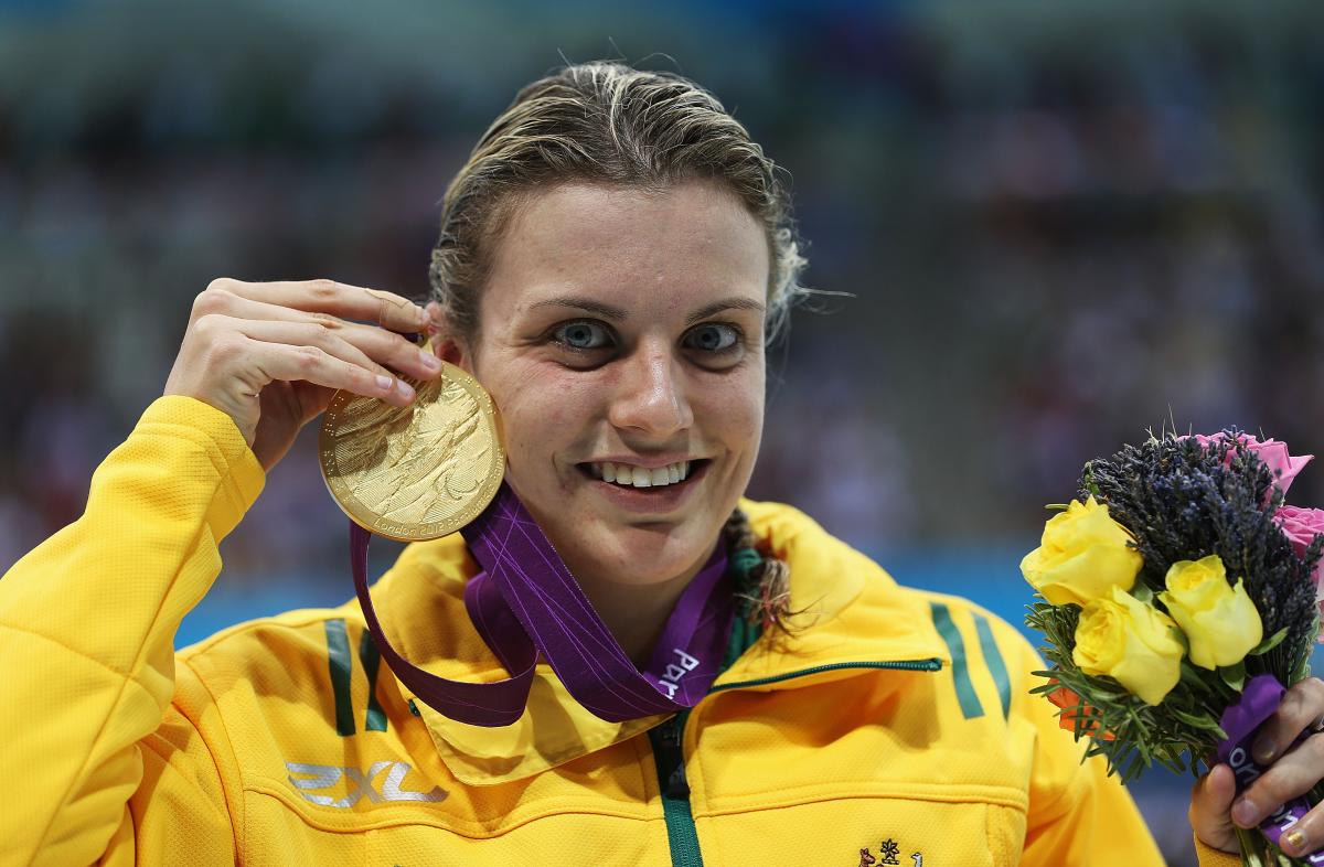 A picture of a woman showing her gold medal