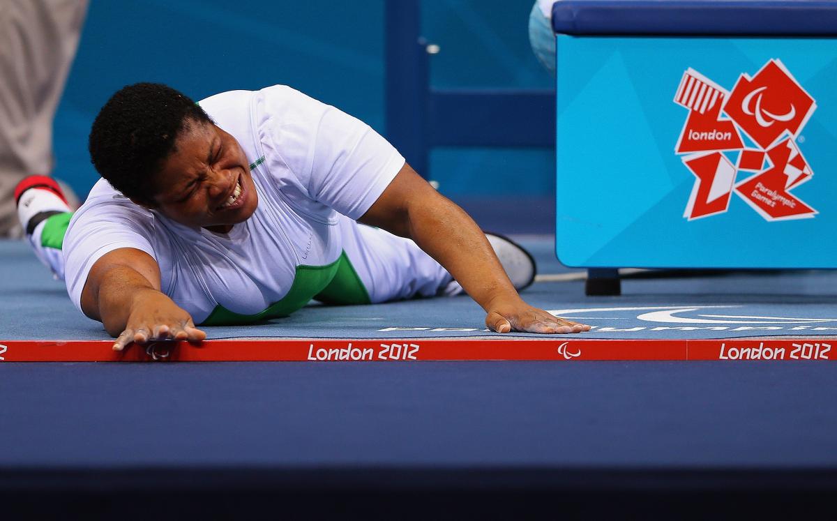 Loveline Obiji of Nigeria celebrates on the floor in the Women's -52 kg Powerlifting event.