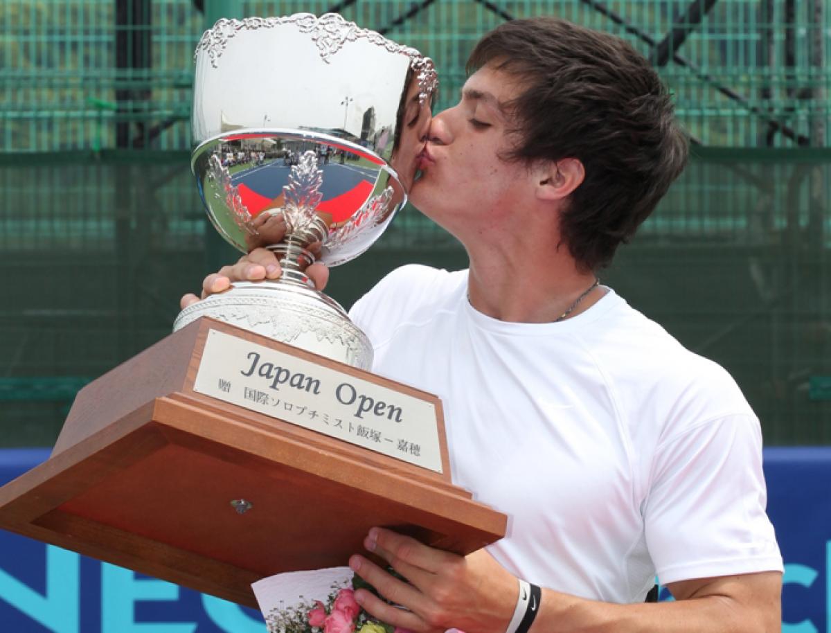 A picture of a man kissing his trophy after his victory