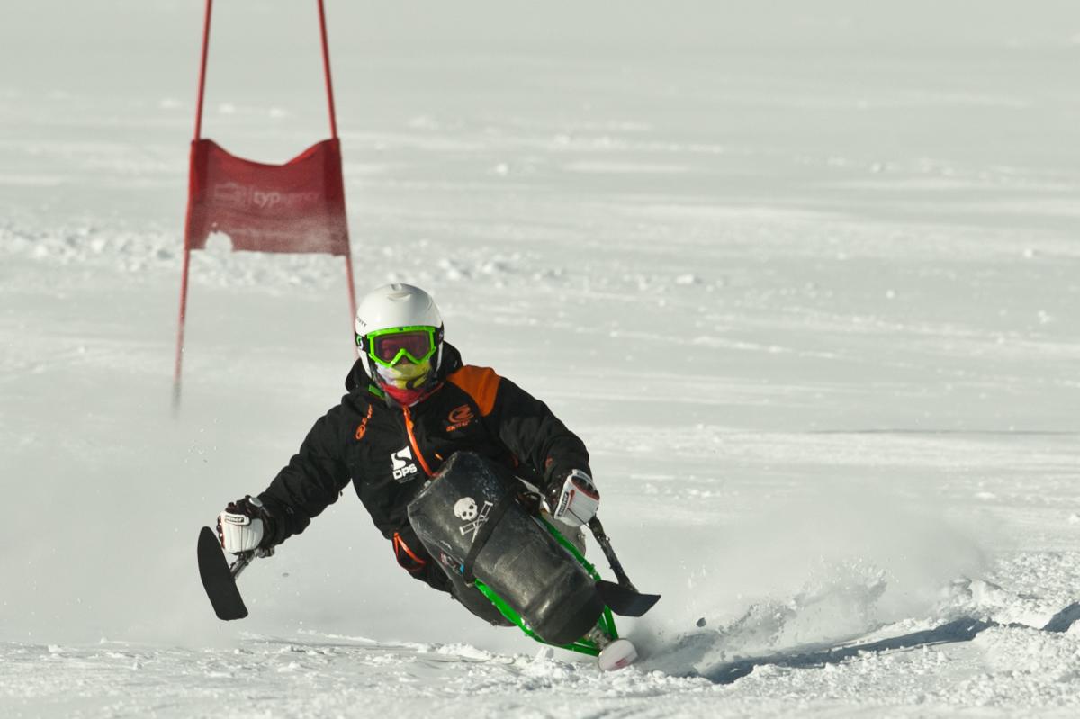 A picture of man in a sldge skiing