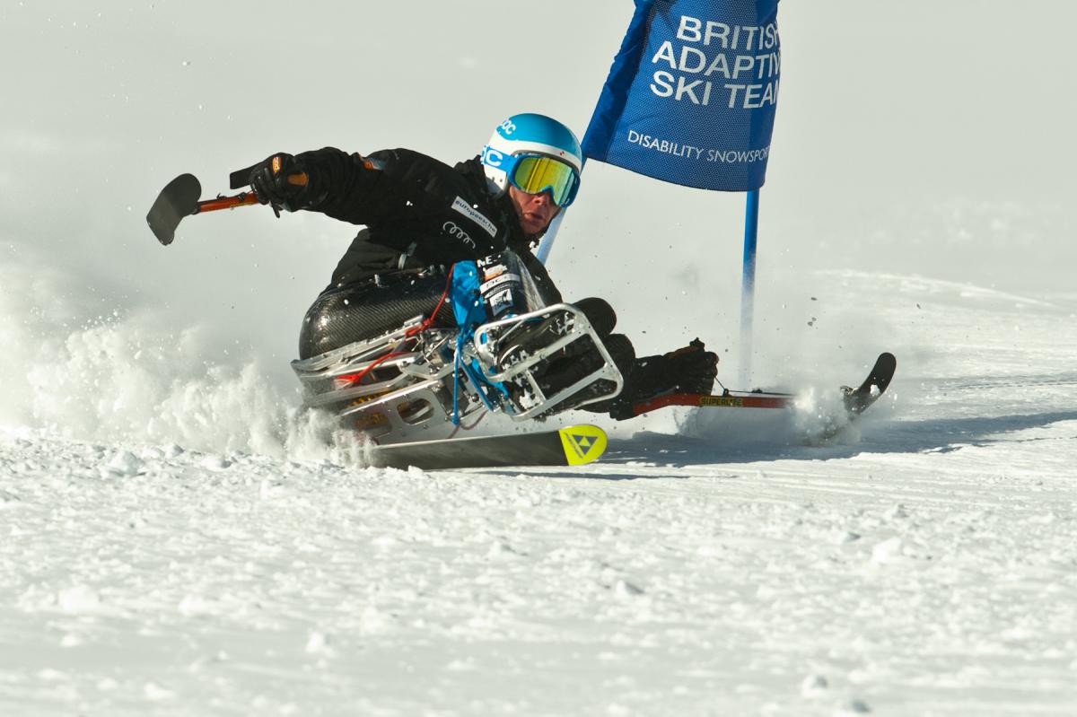 A picture of a man in a sledge skiing