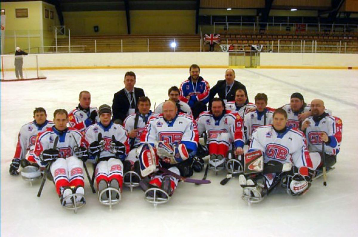 A picture of a sledge hockey team posing for a group picture
