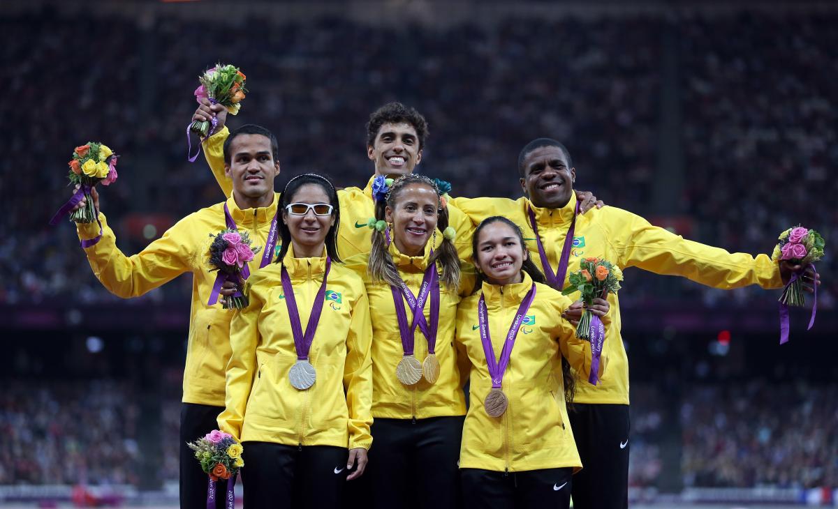 A picture of six person on a podium showing their medals