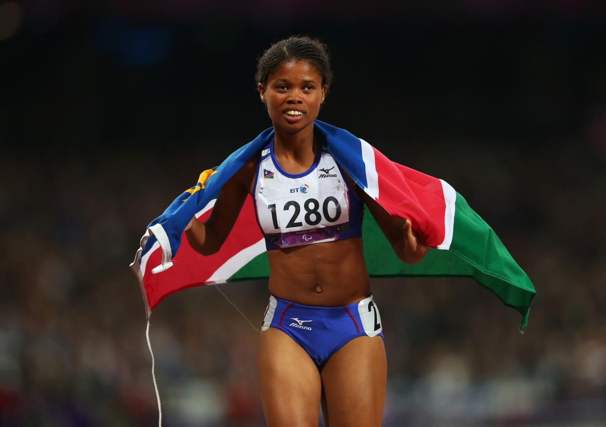 A picture of a woman wearing a Namibian flag celebrating her victory