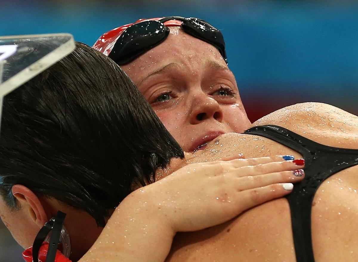 A picture of two women crying after their performances during a swimming race.
