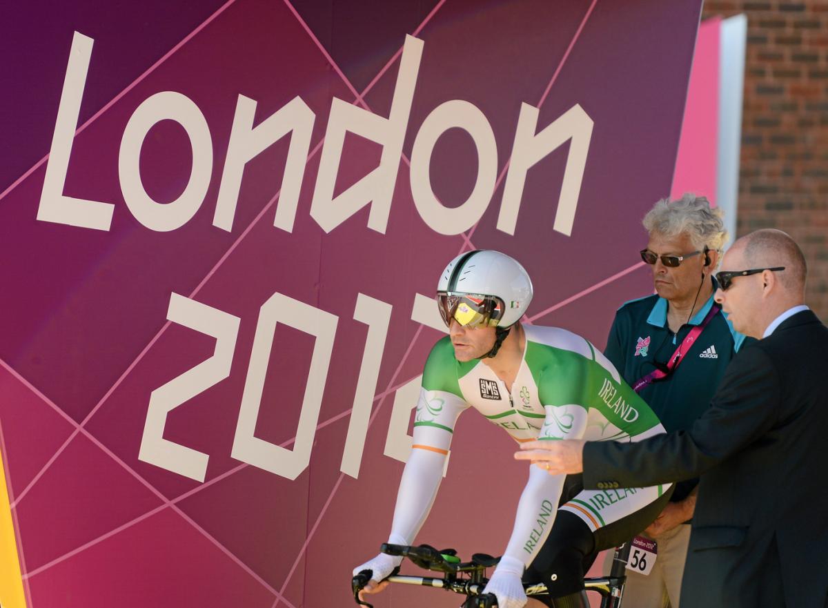 A picture of a man waiting for it's start during a para-cycling race.