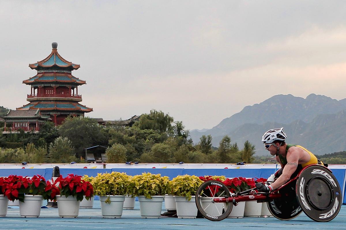 A picture of a man in a wheelchair racing. 