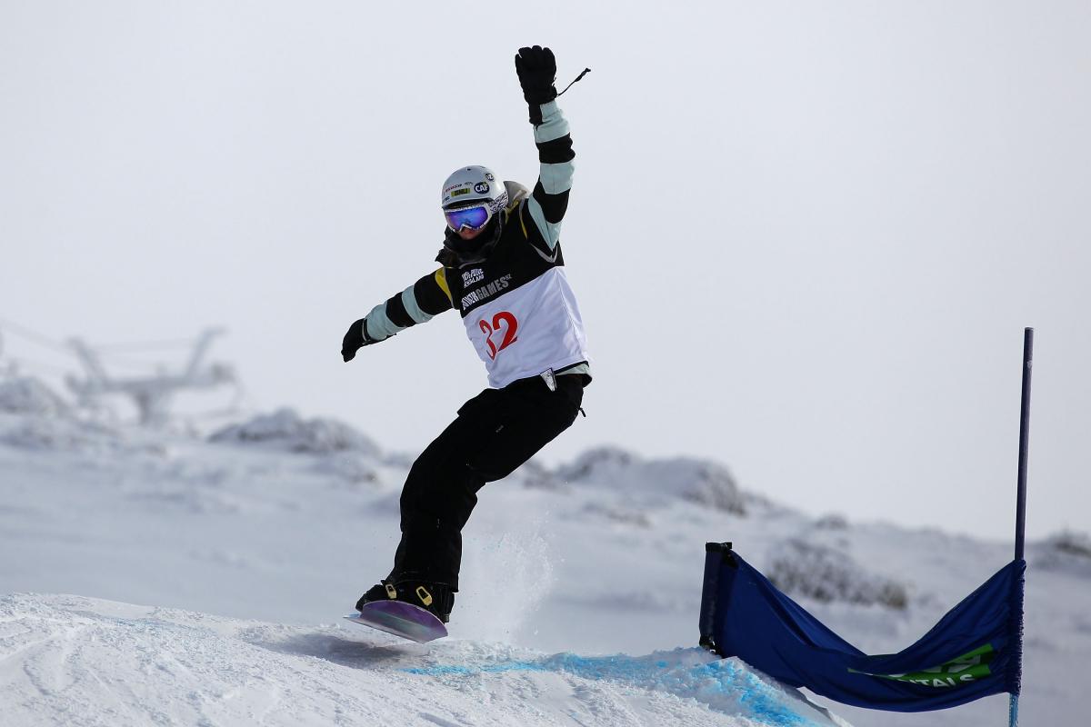 A picture of a woman jumping with a snowboard