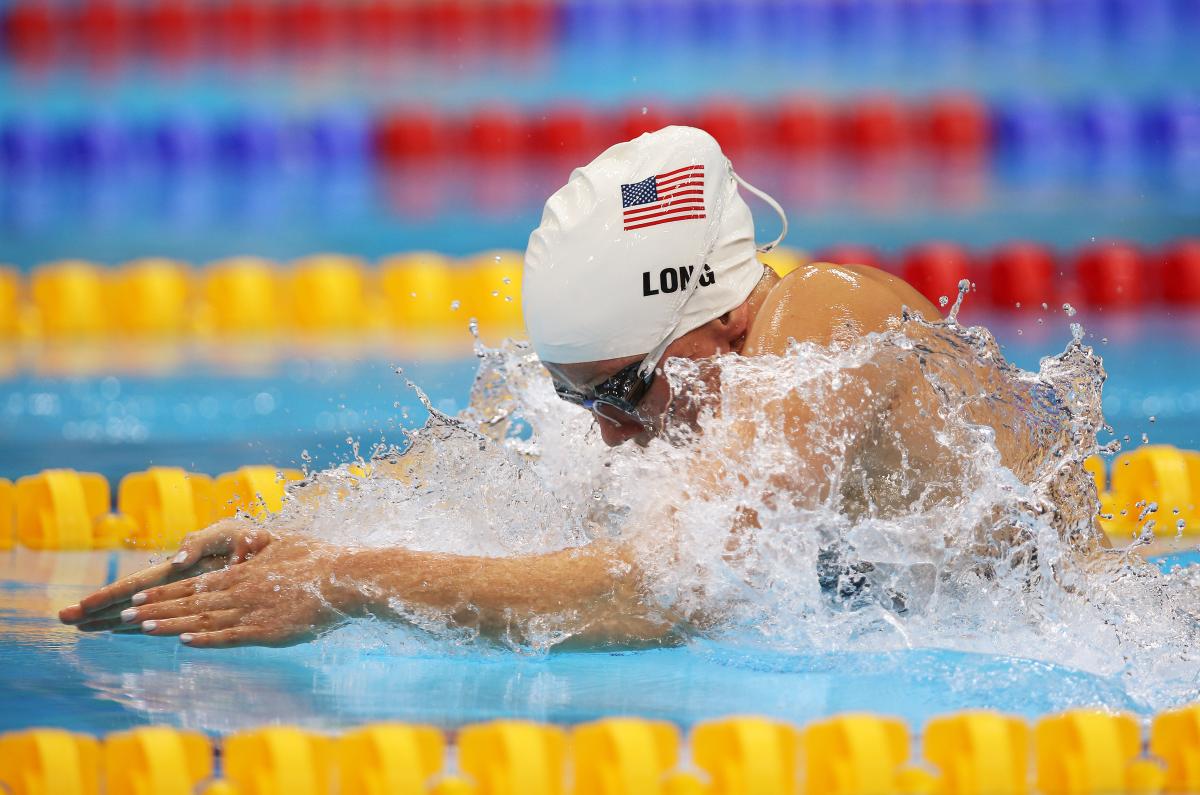 A picture of a woman in the pool with her head and hands above the surface