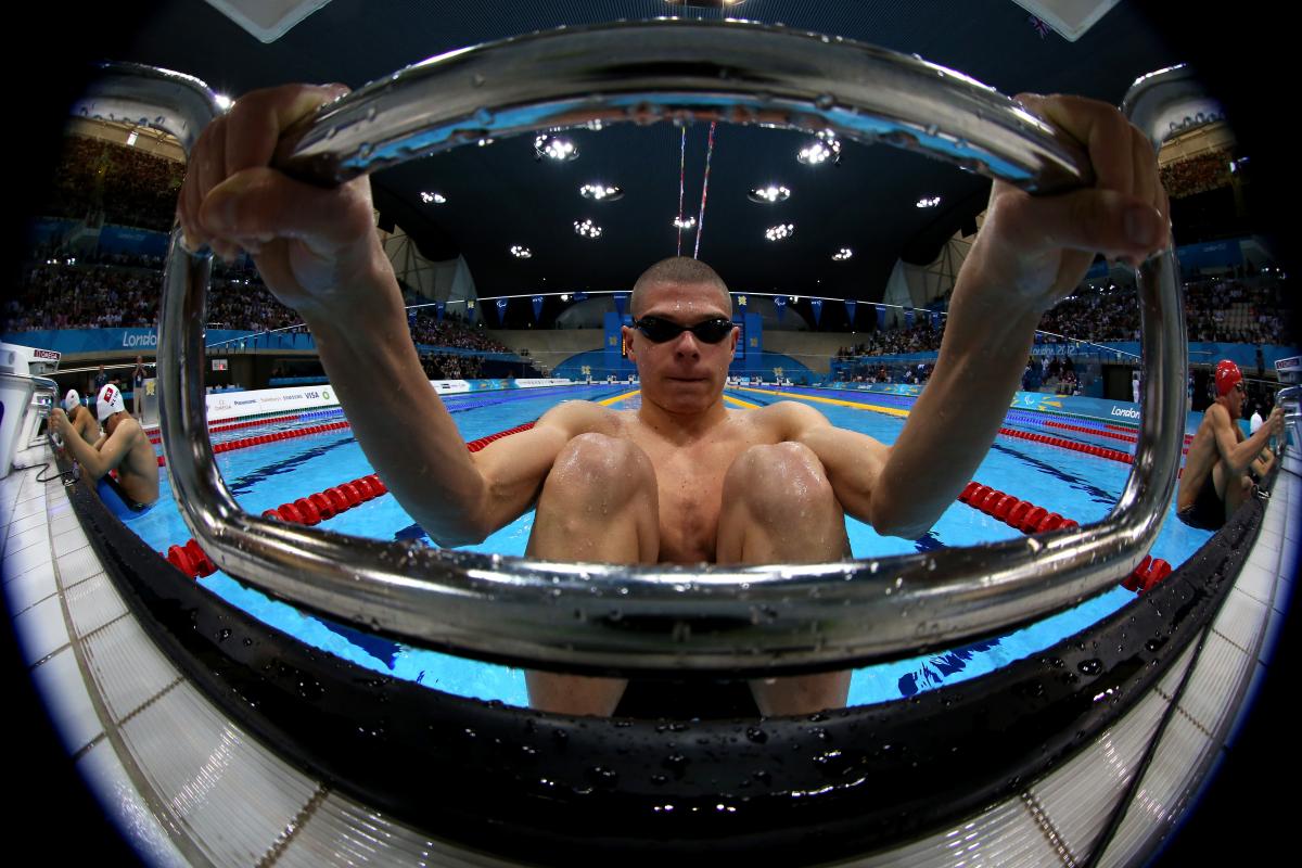 A picture of a man holding the starting block with his hands