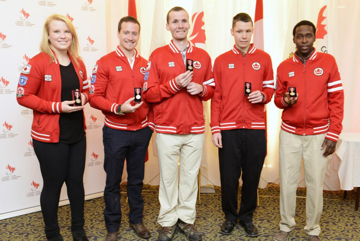 A picture of athletes posing for a group picture with their trophies