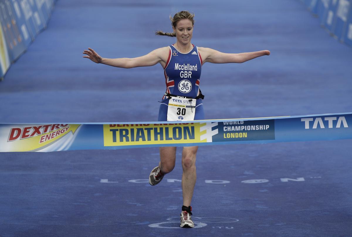 A picture of a woman crossing a finish line after a triathlon race