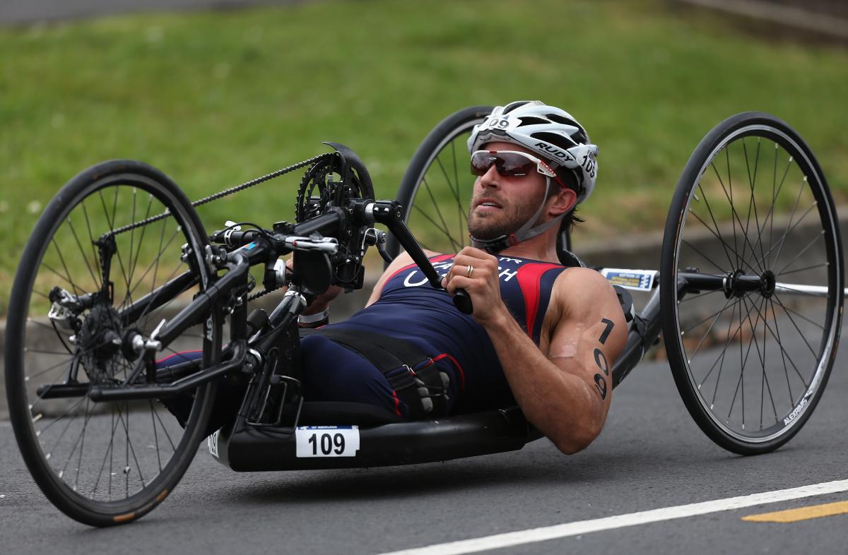 A picture of a man without leg cycling in a hand-cycle