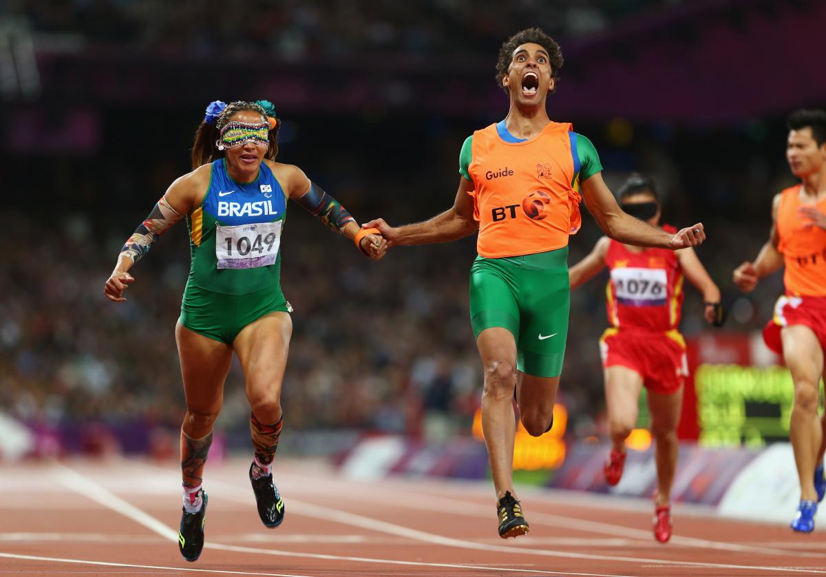 A picture of a woman with the guide running on the track