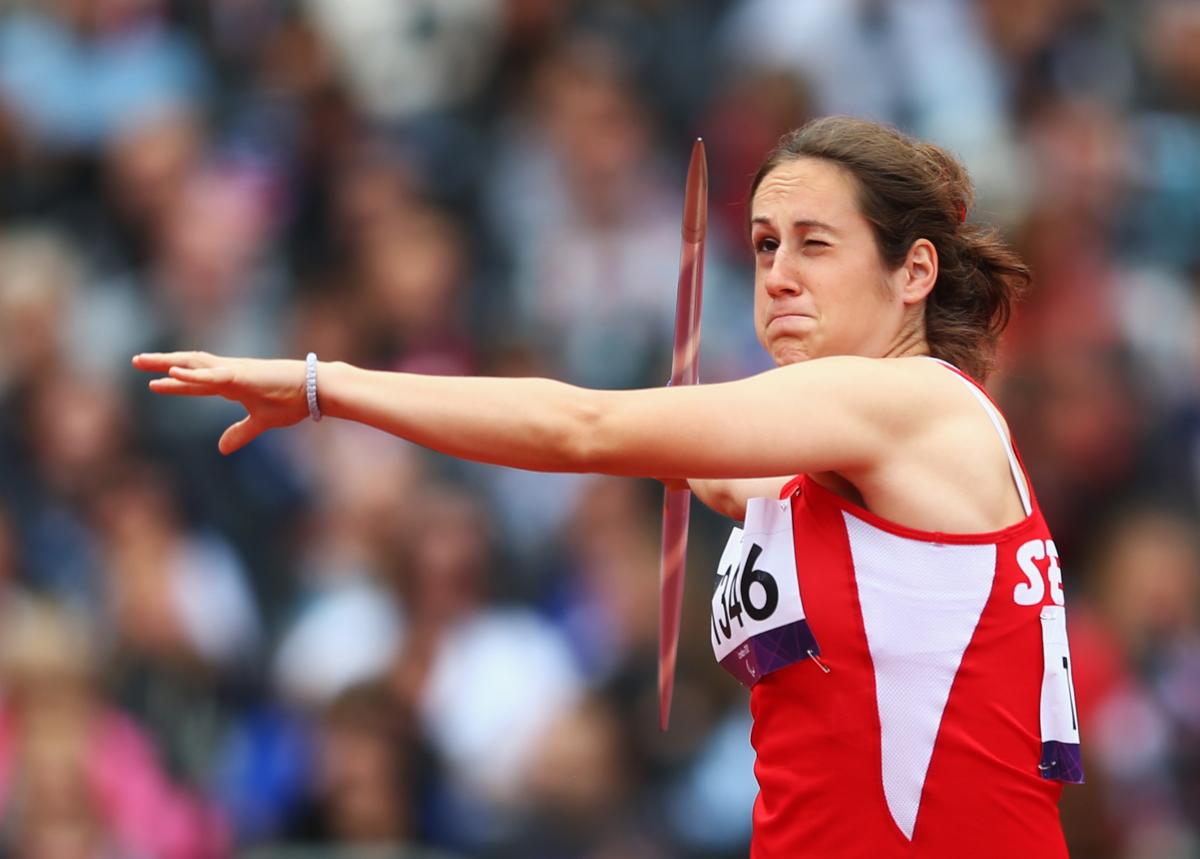 A picture of a woman in the field throwing the Javelin