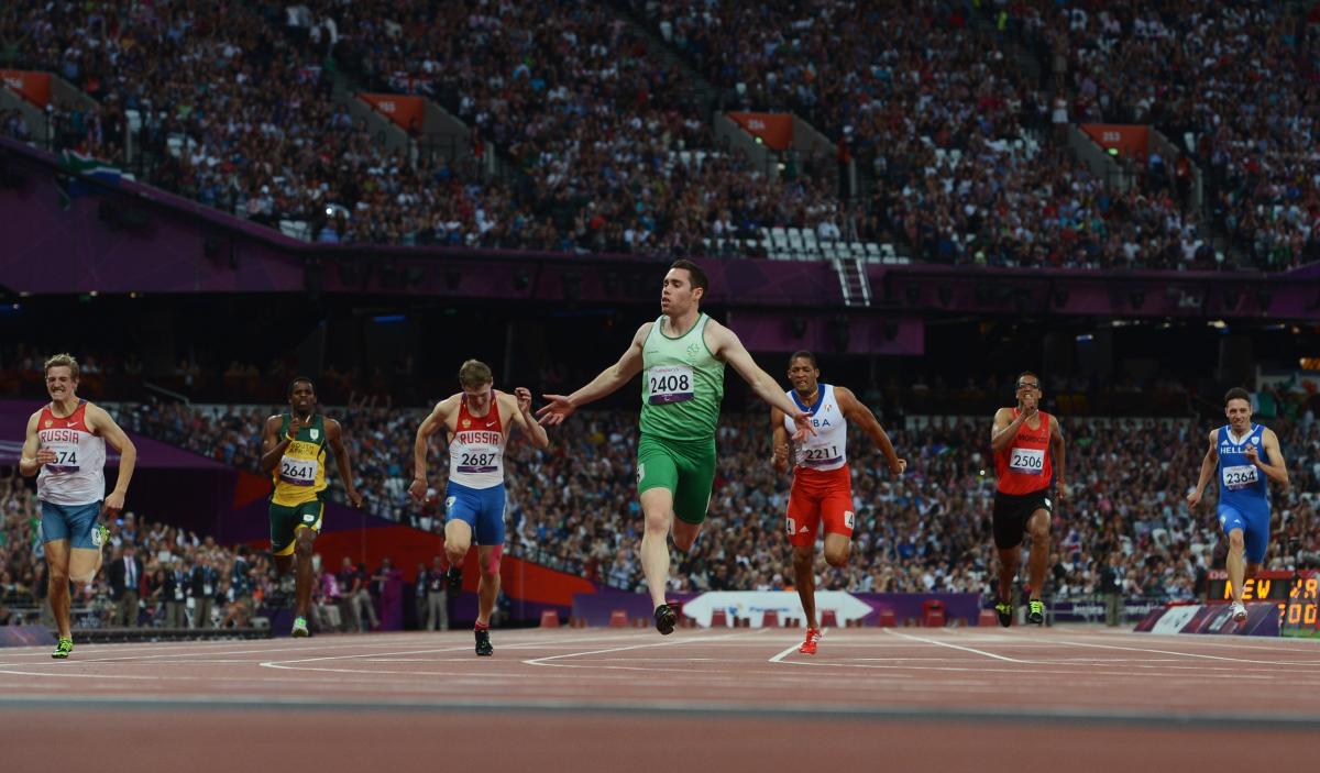 A picture of a man on a track crossing a finishing line