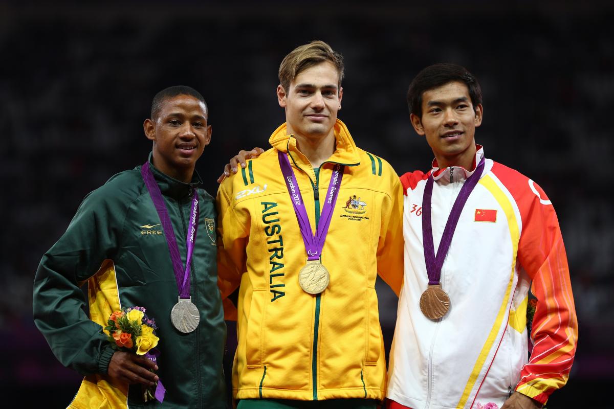 A picture of men on a podium with medals around their neck