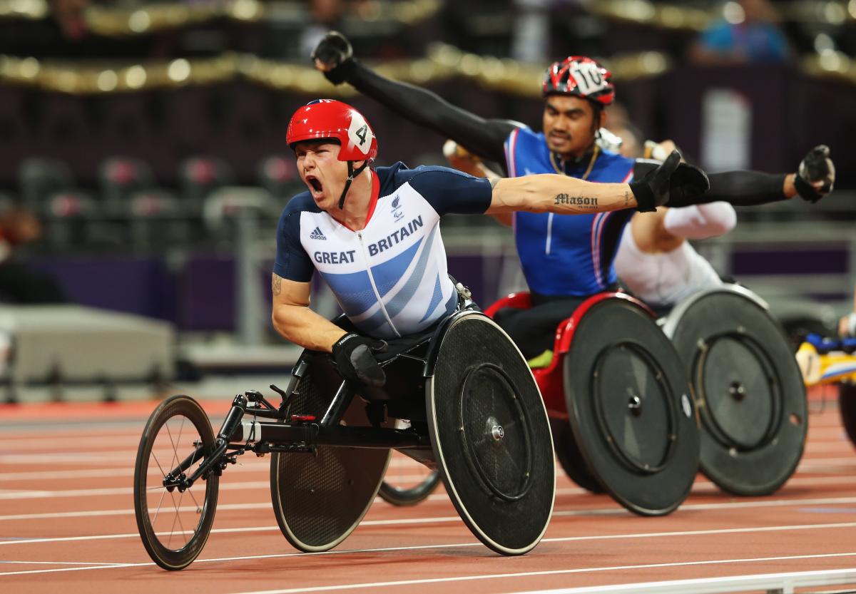 A picture of men in a wheelchair racing on a track