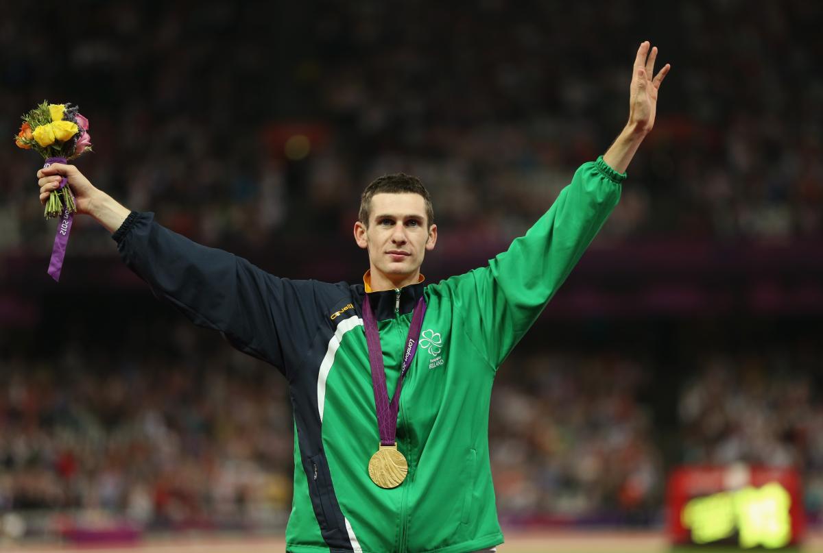 A picture of a man on a podium with a medal around his neck