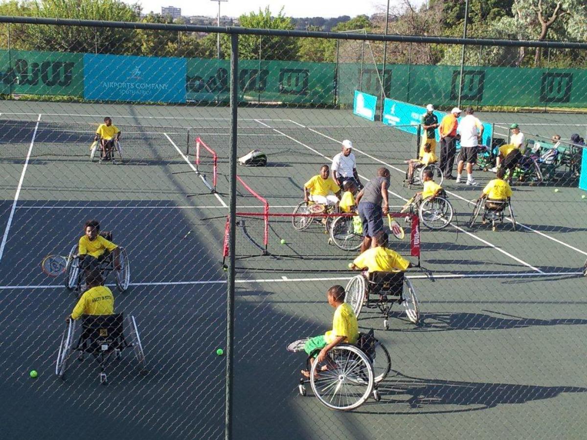 A picture of person in wheelchairs playing tennis