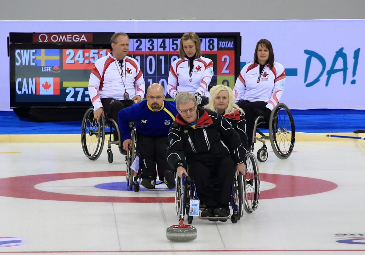 A picture of person in wheelchairs playing curling