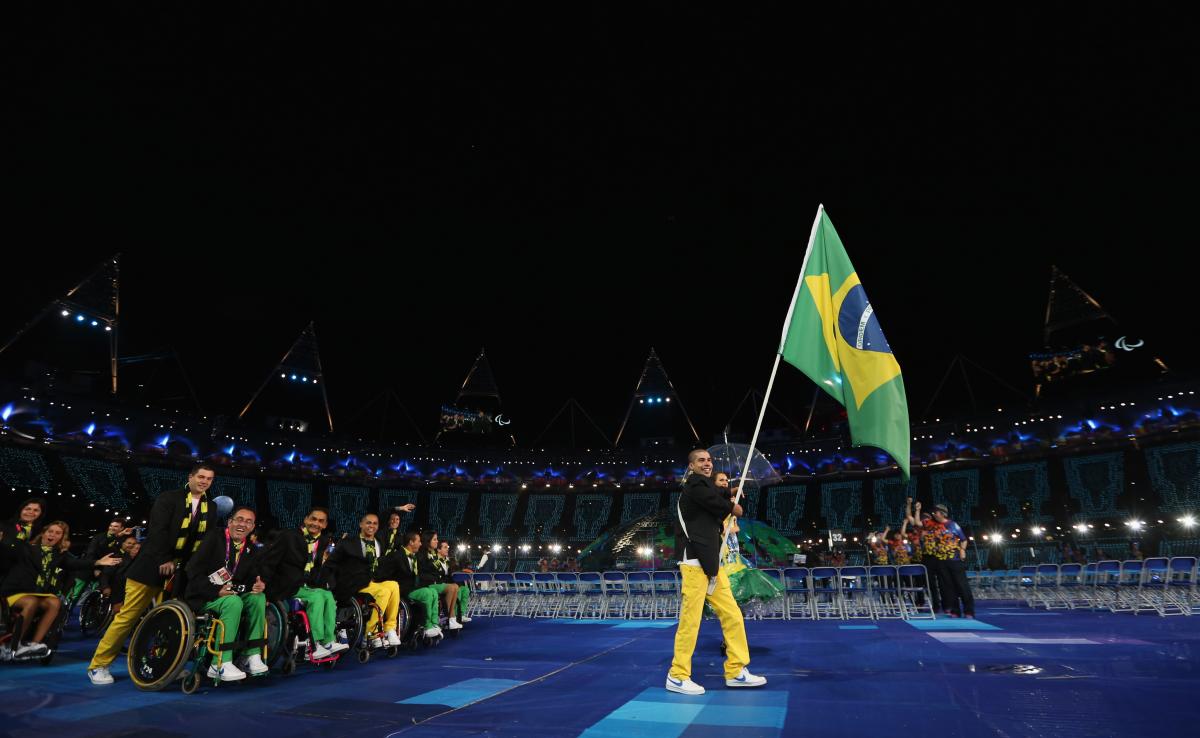 A picture of a man holding a brazilian flag