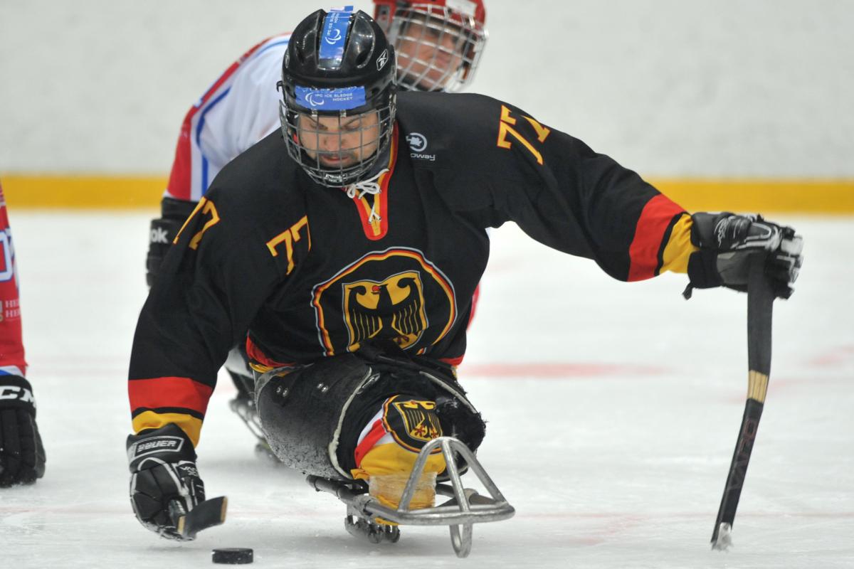 A picture of a man in ssledge playing ice hockey