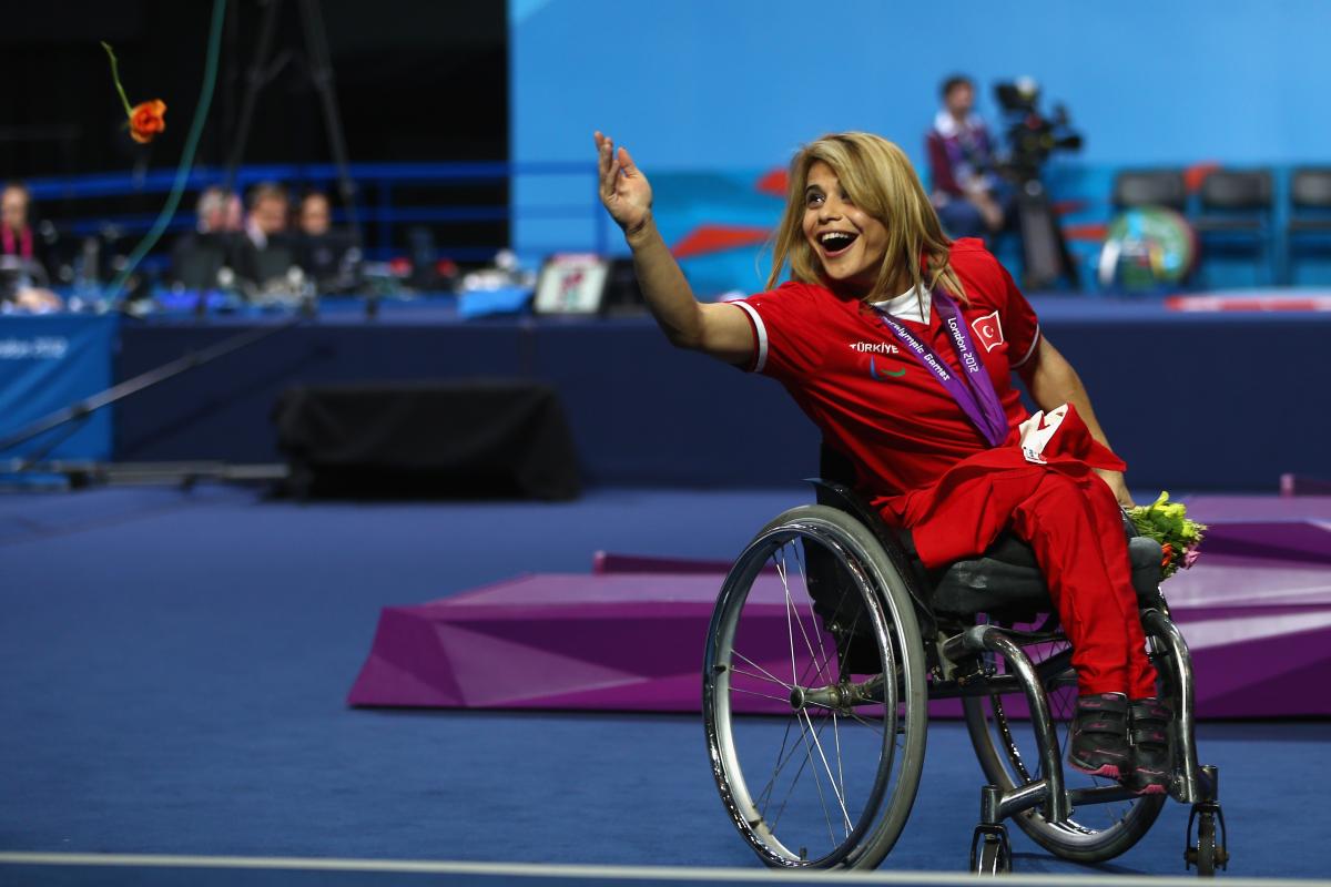 A picture of a woman on a podium with a medal around her neck