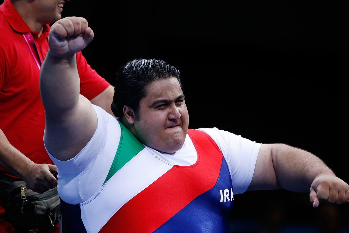 A picture of a powerlifter celebrating victory with his hand up